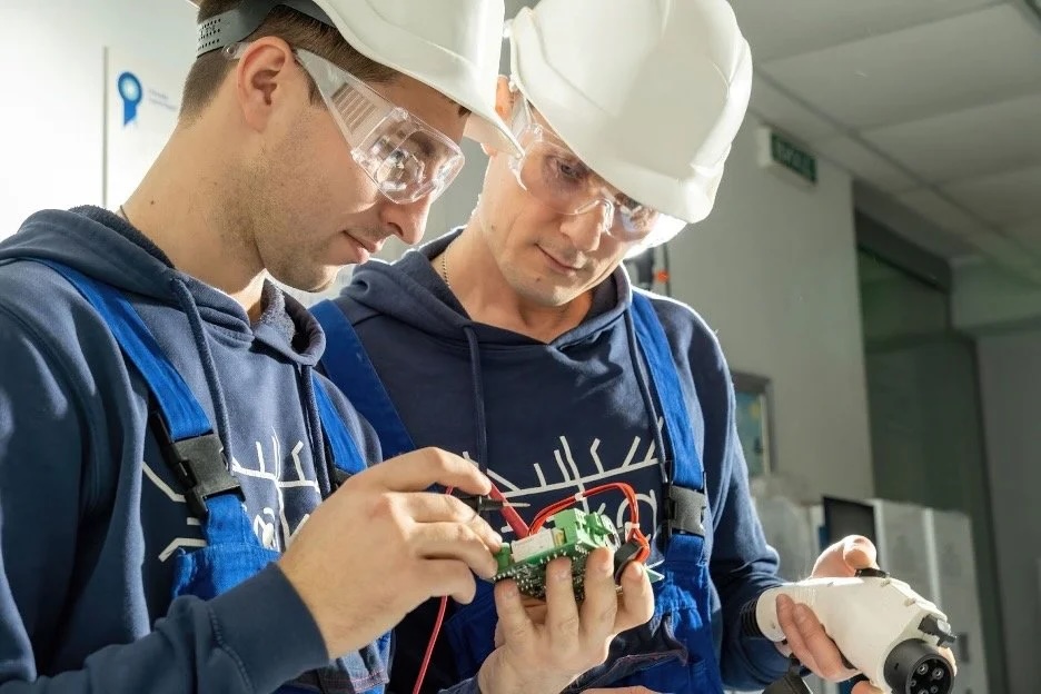 electricians examine EV circuit board
