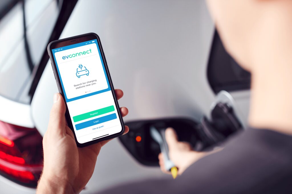 man holding phone with EV Connect app